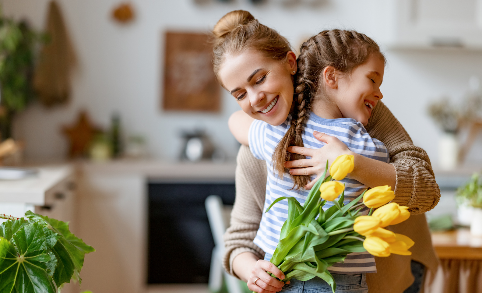 Happy mother receiving flowers from daughter