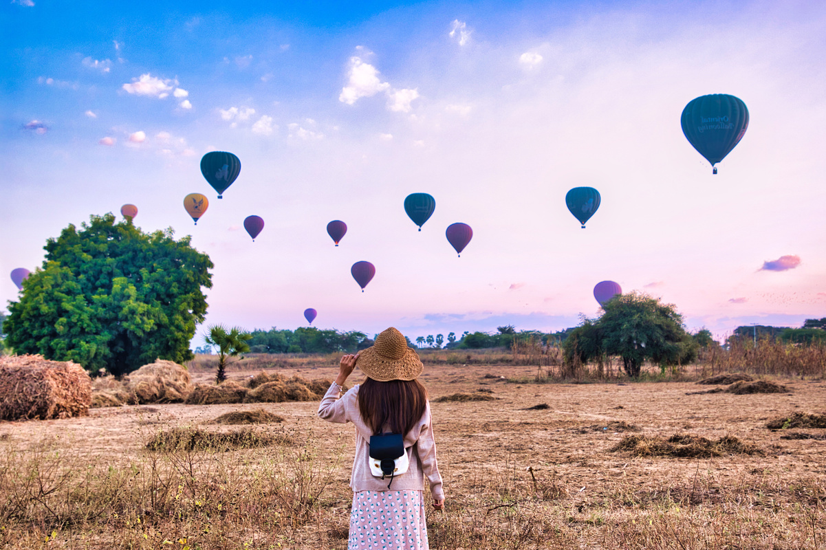 Woman Looking at Sky with Hot Air Balloons